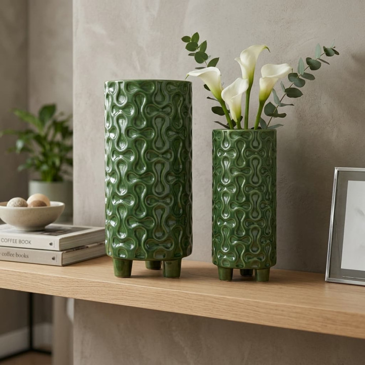 Decorative green embossed ceramic vases on a shelf