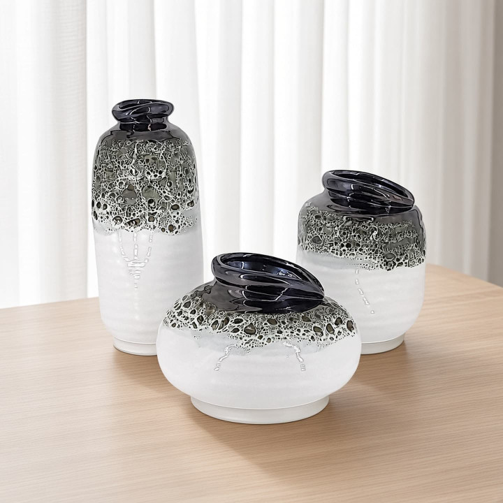 Three white and moss green ceramic vases front view